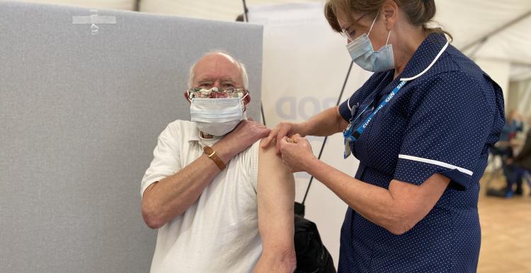 Nurse giving Covid vaccine to man