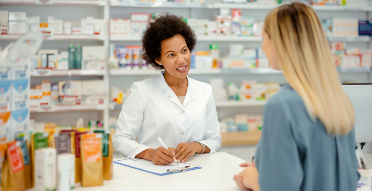 female pharmacist talks to female customer across a counter in a pharmacy
