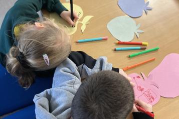 two young carers sat writing at a table