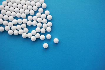 pile of white pills on blue background