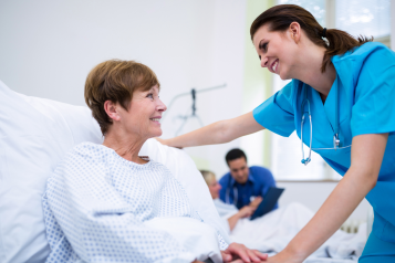 female doctor attending female patient in hospital bed