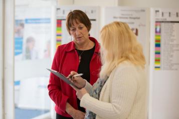 woman with clipboard talking to another woman