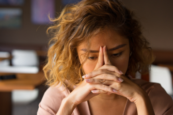 young woman with head leaning on hands