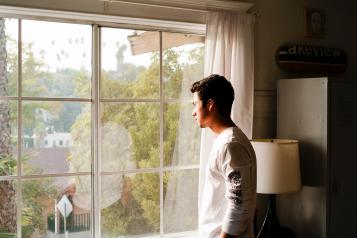 man looking out of window