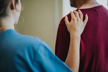 person placing hand on another person's shoulder